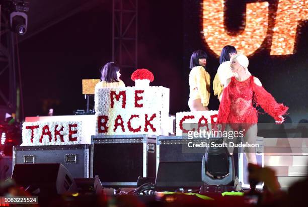 Singer Cardi B is presented a 'Take Me Back' card onstage by Offset during day 2 of the Rolling Loud Festival at Banc of California Stadium on...