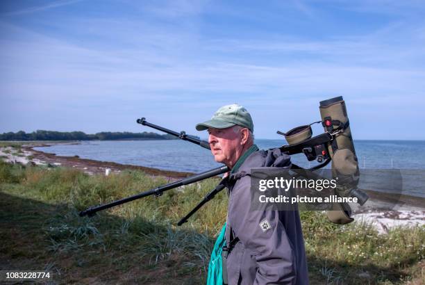 September 2018, Mecklenburg-Western Pomerania, Malchow : Horst Zimmermann goes with a spotting scope, an observation telescope with up to 60-fold...