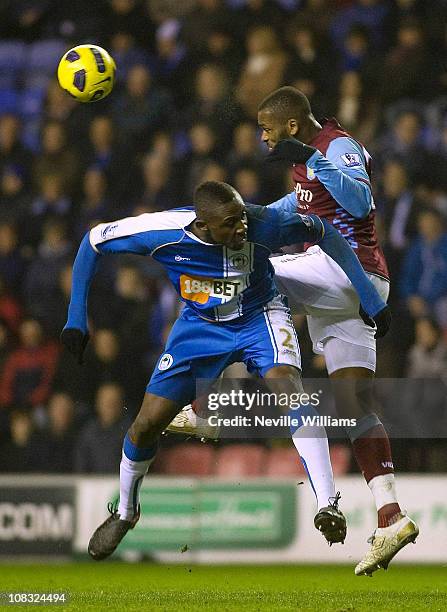 Darren Bent of Aston Villa is challenged by Steve Gohouri of Wigan Athletic during the Barclays Premier League match between Wigan Athletic and Aston...