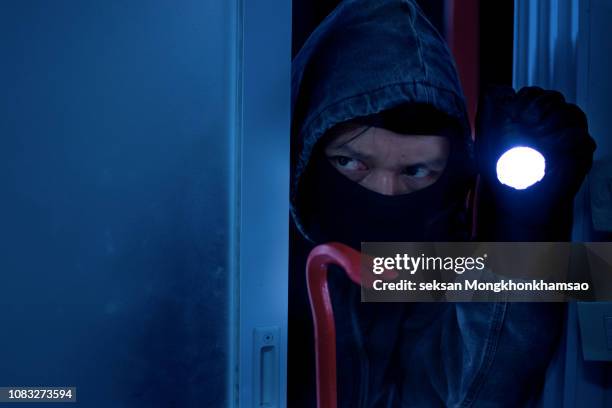 masked robber or thief with balaclava is opening door with crowbar. - car isolated doors open stock pictures, royalty-free photos & images
