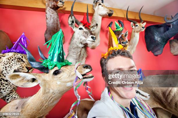 man wearing a party hat celebrating his birthday - hunting trophy stock pictures, royalty-free photos & images