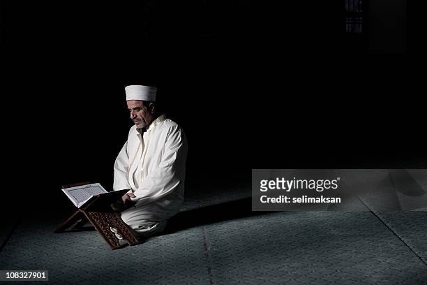 real muslim imam reading koran on lectern in mosque - koran stock pictures, royalty-free photos & images