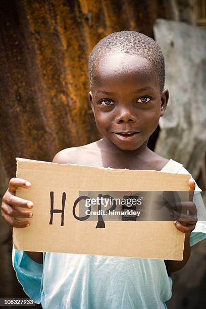 african boy holding a sign with "hope" written on it - liberian culture stock pictures, royalty-free photos & images