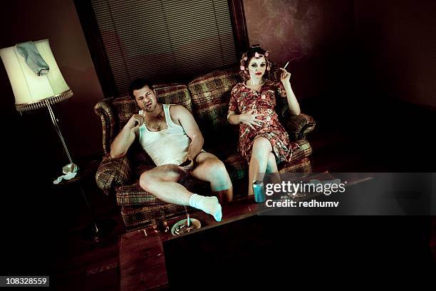 slob couple watching television with pregnant woman smoking - 1970s television set stock pictures, royalty-free photos & images