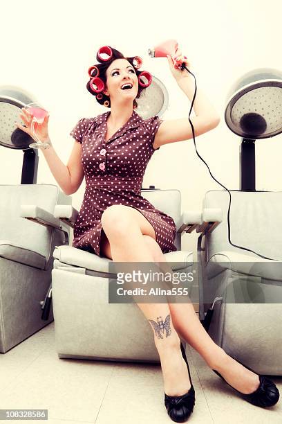 pin-up girl: sexy woman wearing rollers in a beauty salon - pin up girl tattoo stock pictures, royalty-free photos & images