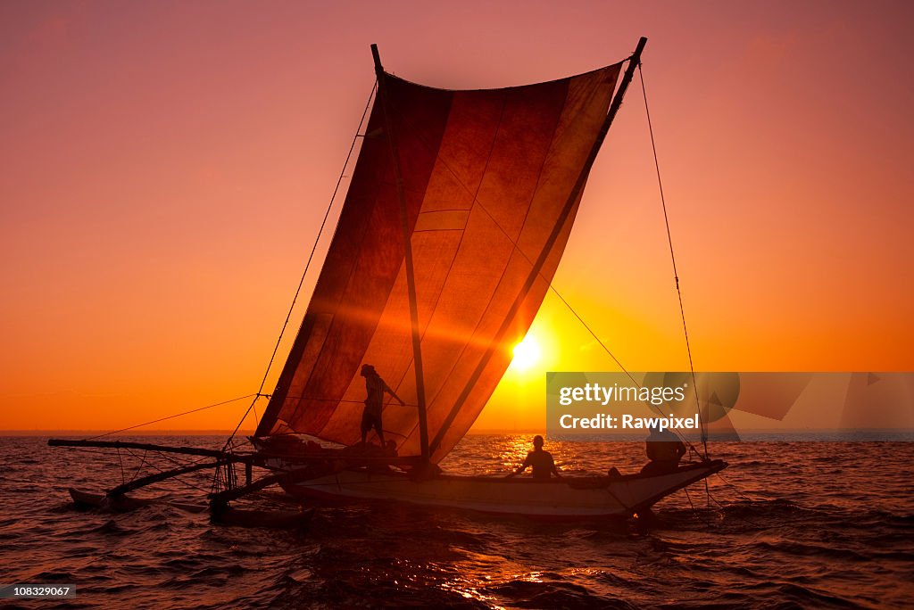 Fishermen on a catamaran at sunrise