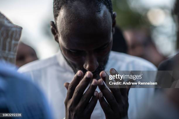 Man prays at the burial of Abdalla Mohamed Dahir and Feisal Ahmed on January 16, 2018 in Nairobi, Kenya. The two men who worked together were killed...