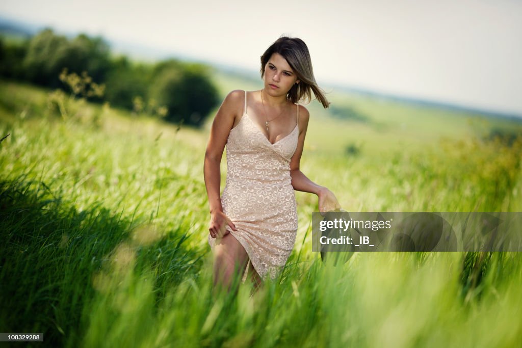 Young beautiful girl walk on grass