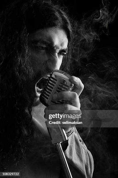 seventies rock star singing on old fashioned microphone - heavy metal stock pictures, royalty-free photos & images