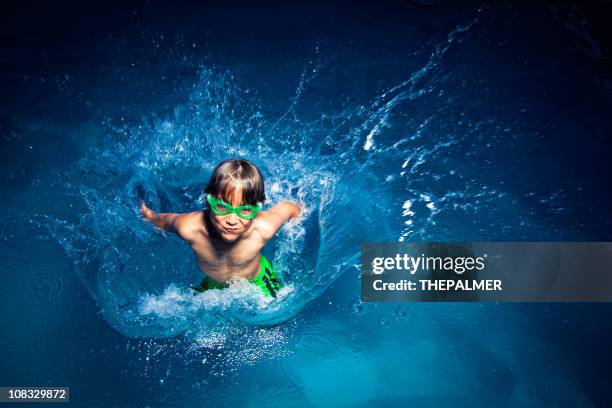 kid making a big splash in the pool - kid jumping into swimming pool stock pictures, royalty-free photos & images