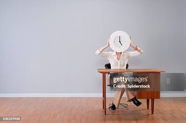 stylish woman holding clock - one empty desk stock pictures, royalty-free photos & images