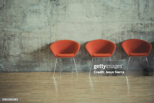 row of empty chairs by wall - lounge chair - fotografias e filmes do acervo