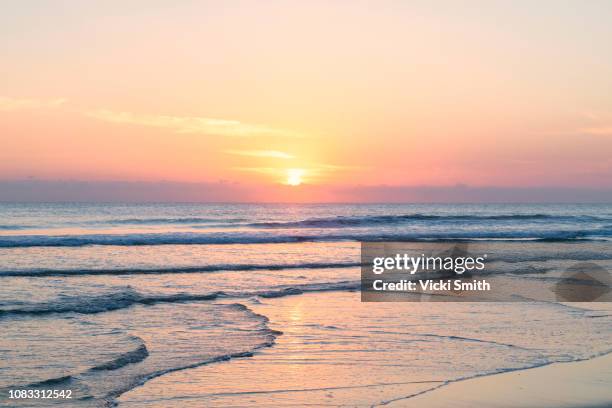 vibrant sunrise over the ocean - sunrise beach stock-fotos und bilder