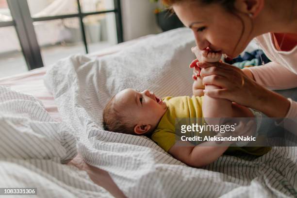 bebé sonriente y su mamá - baby human age fotografías e imágenes de stock