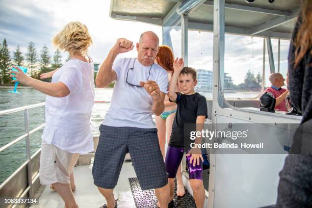 australian family enjoys the end of big day swimming in the ocean and dancing on their boat. - family holidays australia stock-fotos und bilder