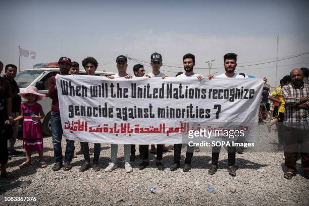 Yazidis at Zakho refugee camp seen holding a banner on the anniversary of the yazidi genocide in Sinyar. On August 3 the Islamic State destroyed the...