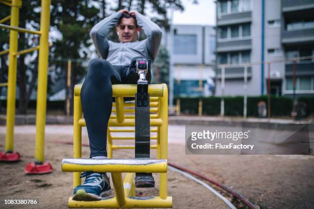 Dedicated adaptive athlete training outdoors doing sit-ups
