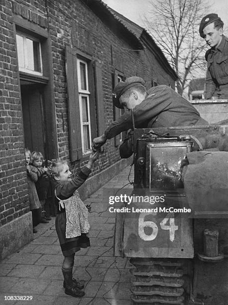 Allied servicemen stop to hand out sweets to Dutch children during the Allied liberation of the Netherlands, summer 1944. Original Publication:...