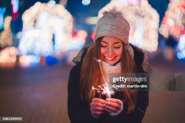 glückliche frau an silvester halten brennende wunderkerze - neujahr 2018 stock-fotos und bilder