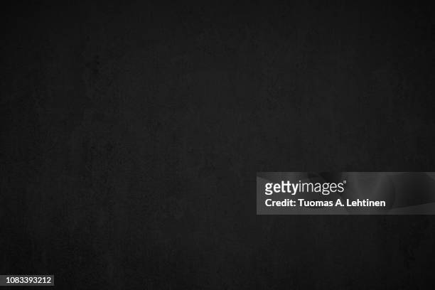 close-up of a weathered and aged dark gray, almost black, concrete wall, texture background. - black stone background imagens e fotografias de stock