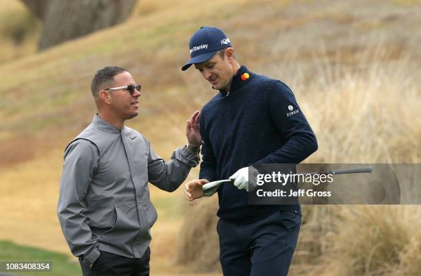 Justin Rose of England and swing coach Sean Foley talk prior to the start of the Desert Classic at the Jack Nicklaus Tournament Course at PGA West on...