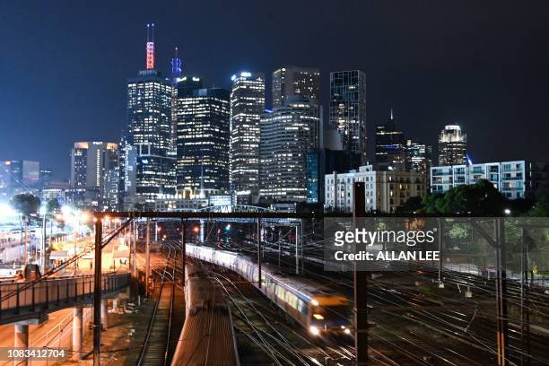 This picture taken on January 16, 2019 shows a train commuting before the city skyline in Melbourne.