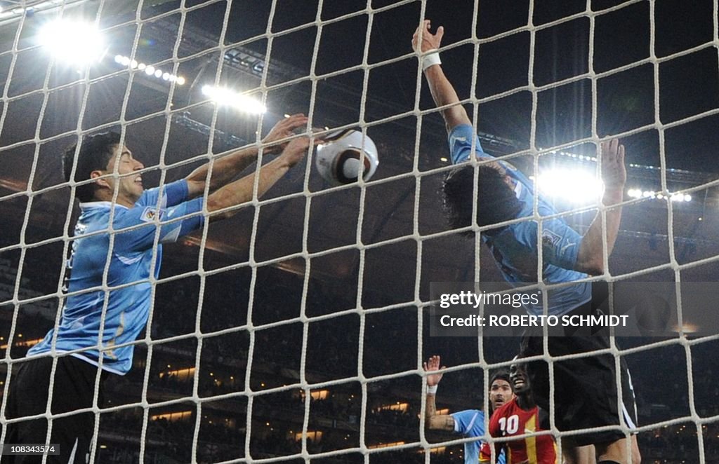 Uruguay's striker Luis Suarez (L) stops