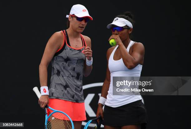 Raquel Atawo of the United States and Katarina Srebotnik of Slovenia talk tactics in their doubles first round match with Amanda Anisimova and...