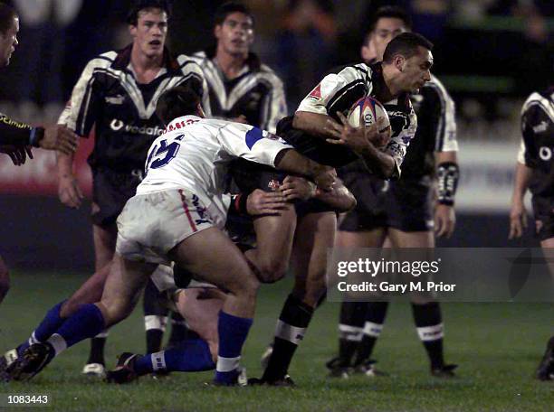 Quentin Pongia of New Zealand is tackled by Laurent Carrasco of France during the Rugby League World Cup Quarter Final match between New Zealand and...