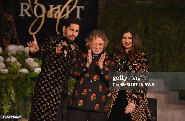 Indian Bollywood actors Siddharth Malhotra and Daina Penty gesture during a fashion show by designer Rohit Bal at the Blenders Pride Fashion Tour in...