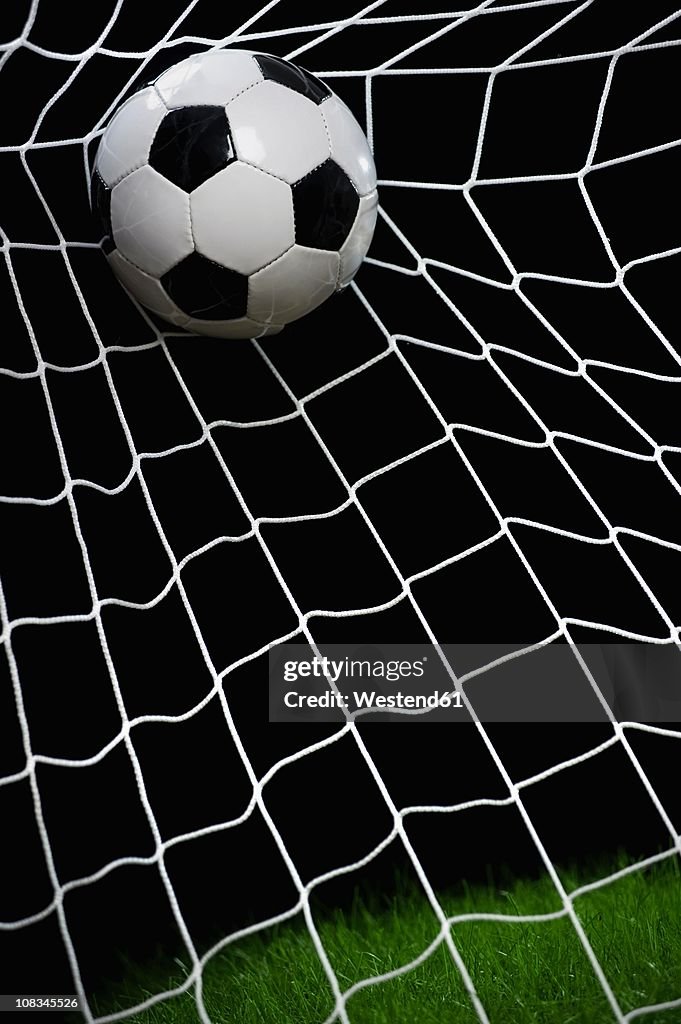 Football striking on net, close up