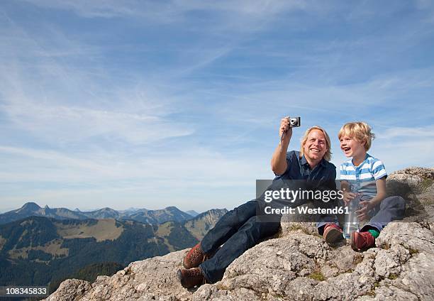 germany, bavaria, father and son (4-5 years) taking photos on mountain summit - 35 39 years stockfoto's en -beelden