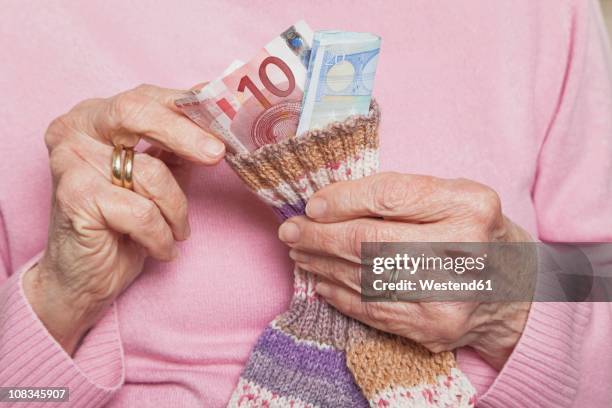 germany, senior woman counting money from money sock, mid section - sock stock pictures, royalty-free photos & images