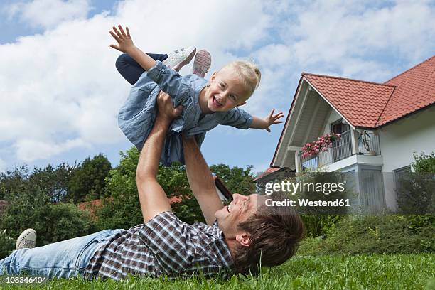 germany, munich, father playing with daughter (2-3 years) in garden - 飛行機のまね ストックフォトと画像