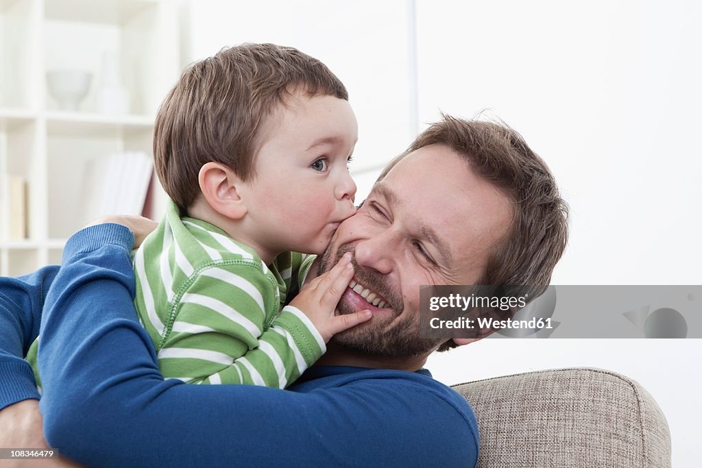 Germany, Bavaria, Munich, Son (2-3 Years) kissing his father, smiling