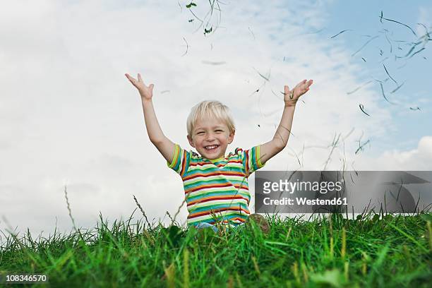 germany, cologne, boy (2-3 years) playing with grass, smiling - 2 3 years stock pictures, royalty-free photos & images