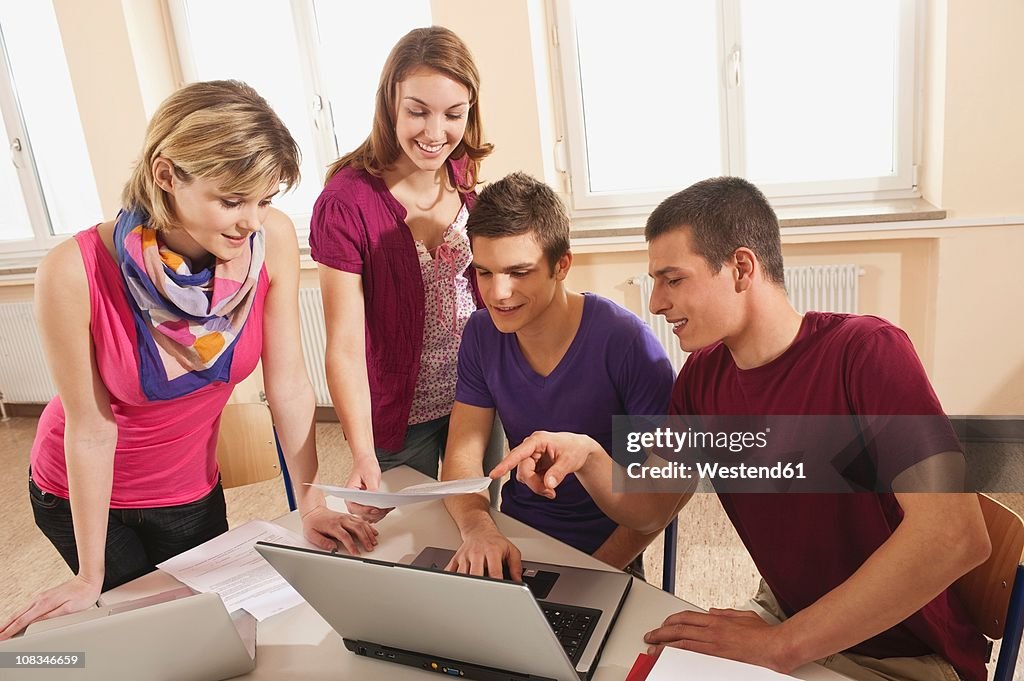 Germany, Emmering, Students discussing and using laptop