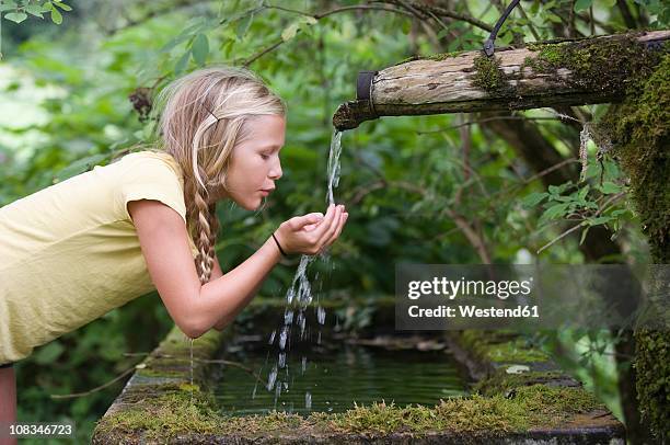 austria, mondsee, girl (12-13 years) drinking water from water spout - drinking fountain stock pictures, royalty-free photos & images