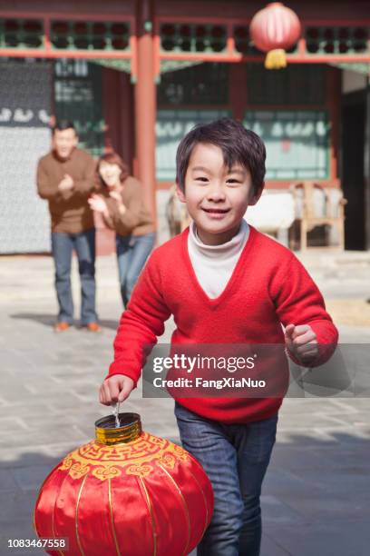 chinesischen jungen tragen traditionelle laterne - chinese lantern festival stock-fotos und bilder