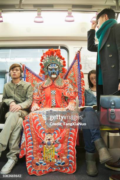 mann in der traditionellen chinesischen oper kostüm u-bahn fahren - chinese opera stock-fotos und bilder