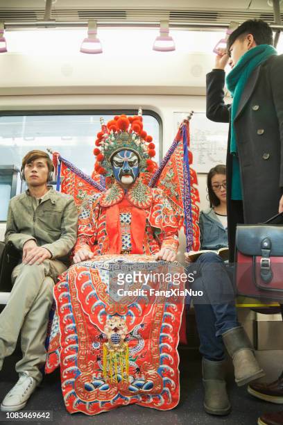 man in traditional chinese opera costume riding subway - fancy dress costume imagens e fotografias de stock