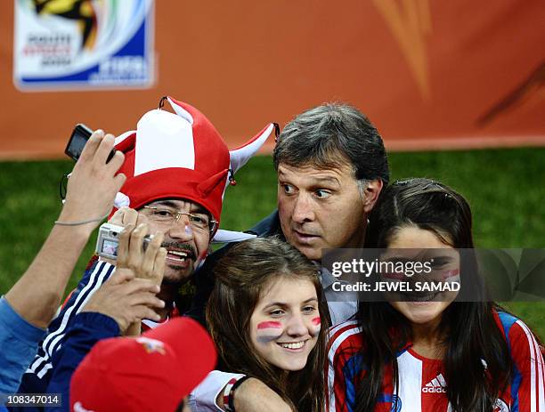 Paraguay's coach Gerardo Martino poses with supporters at the end of the Group F first round 2010 World Cup football match Paraguay vs. New Zealand...