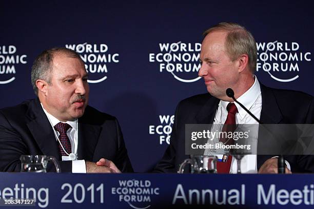 Eduard Khudainatov, chief executive officer of OAO Rosneft, left, shakes hands with Robert "Bob" Dudley, chief executive officer of BP Plc, during a...