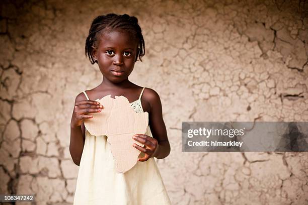 black girl holding a piece of cardboard shaped like africa - indigenous cultures stock pictures, royalty-free photos & images