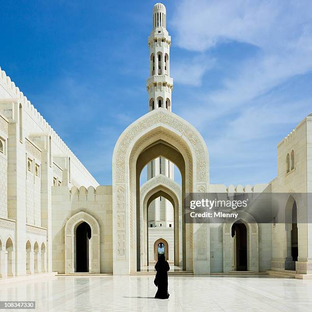 woman walking inside sultan qaboos grand mosque muscat oman - grand mosque oman stock pictures, royalty-free photos & images