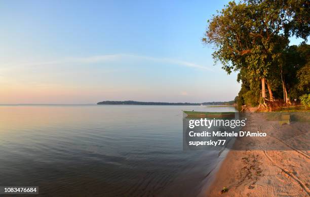 lonely boat on still water in kalangala - lake victoria stock-fotos und bilder