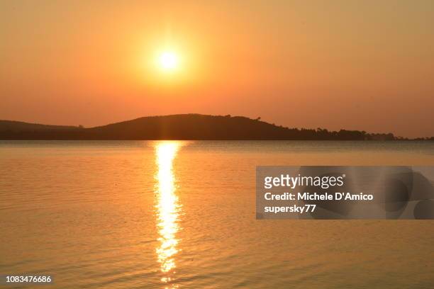 sunset on the still water of lake victoria - lake victoria stock pictures, royalty-free photos & images