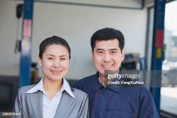 smiling chinese businesswoman and mechanic - asian couple garage car stock pictures, royalty-free photos & images