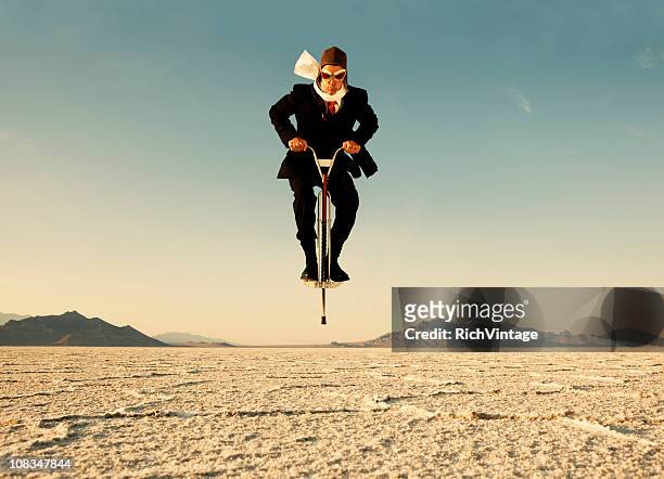 geschäftsmann auf springstock in der wüste - next steps stock-fotos und bilder