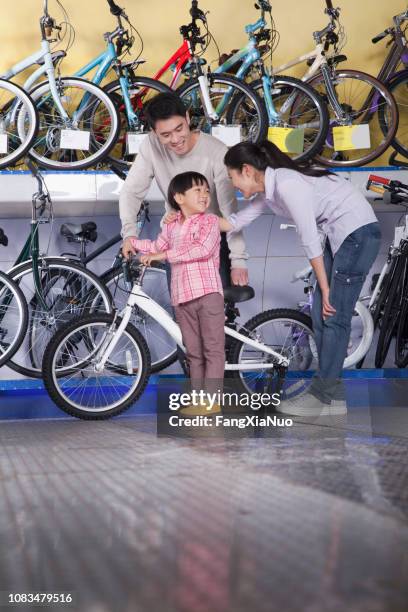 chinese family looking at bicycle in bike shop - young choice beijing activity stock pictures, royalty-free photos & images